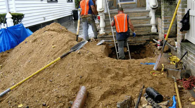 Contractors performing foundation protection and exterior drainage excavation near residential home steps in Savannah, GA